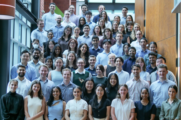 65 new medical interns for 2025 standing on stairs smiling at camera at Austin Health